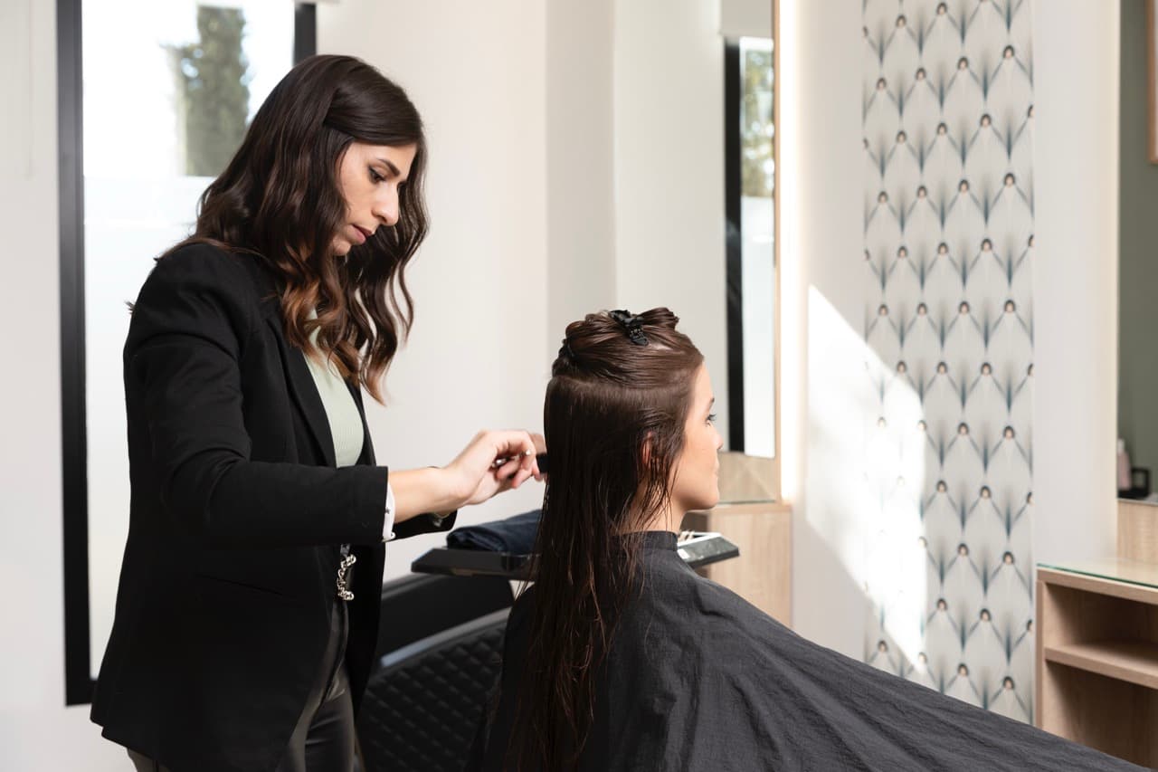 Stylist talking with a client at the mirror during the consultation that drives salon client retention