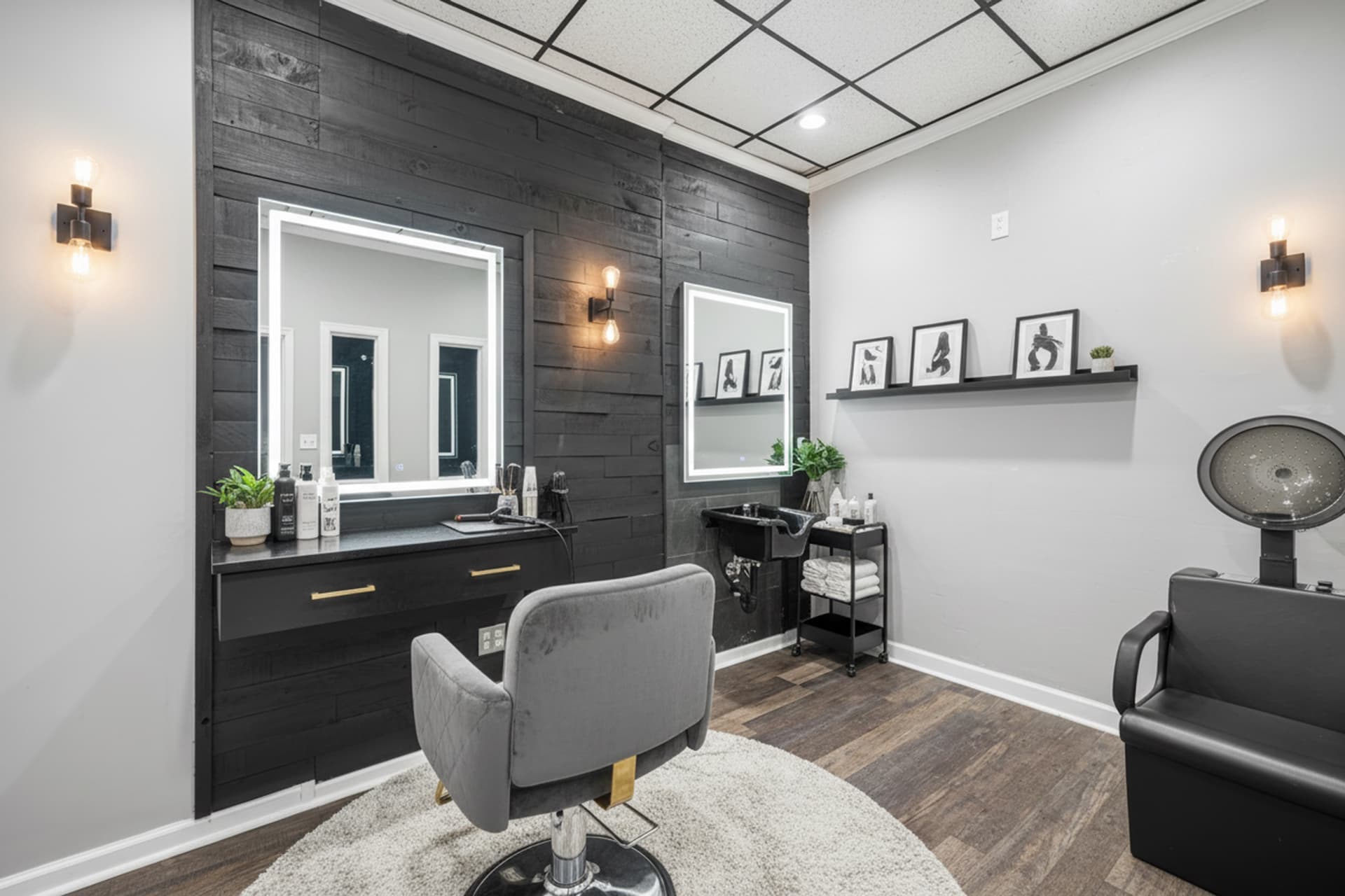 Salon suite styled for beauty branding with a lighted vanity mirror and a dark shiplap accent wall